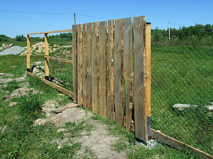 Деревянный забор из необрезной доски фото